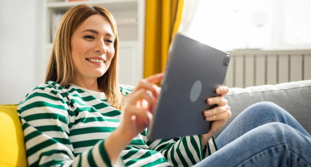 Woman using a tablet at home to find home and auto insurance from a trusted Connecticut Insurance Agency